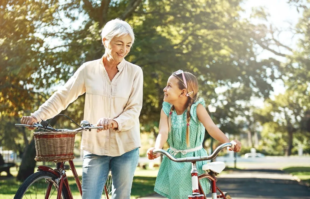 A grandmother riding bikes with her granddaughter, enjoying life with less chemo neuropathy pain
